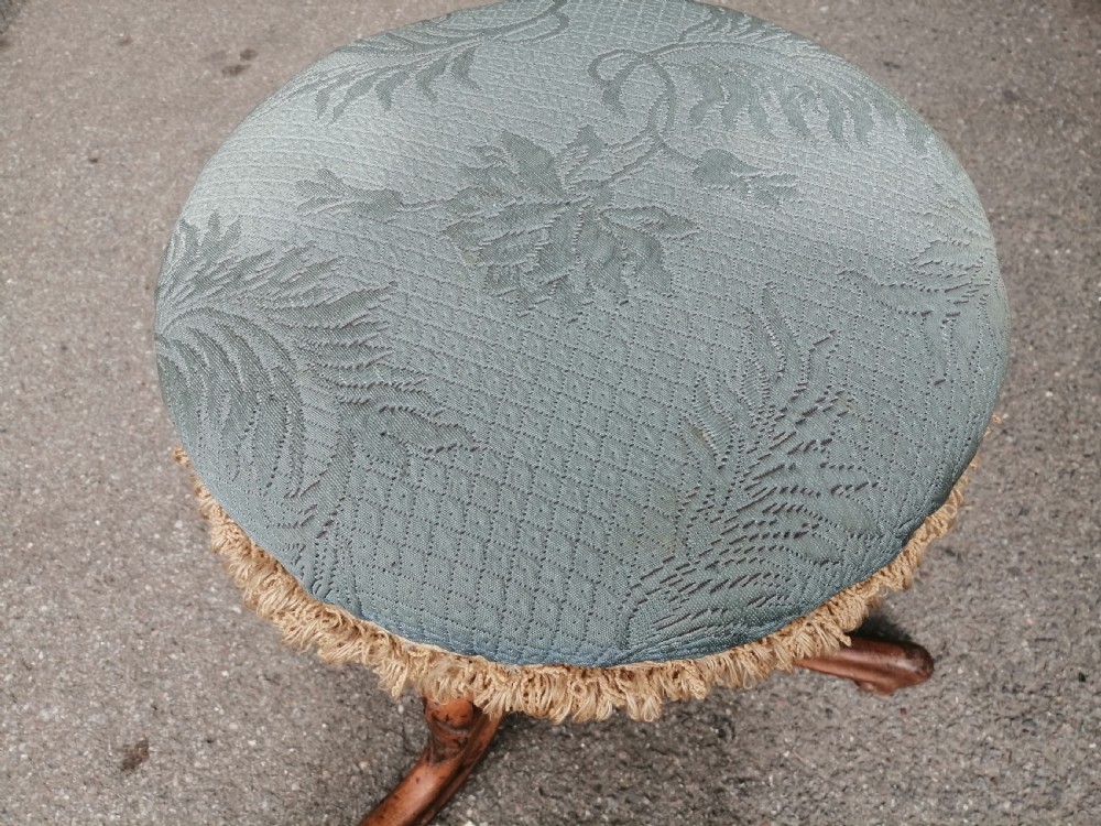 A 19th-century Victorian walnut rise and fall piano stool featuring a circular light blue patterned upholstered seat with fringed trim set on a carved tripod base. View III