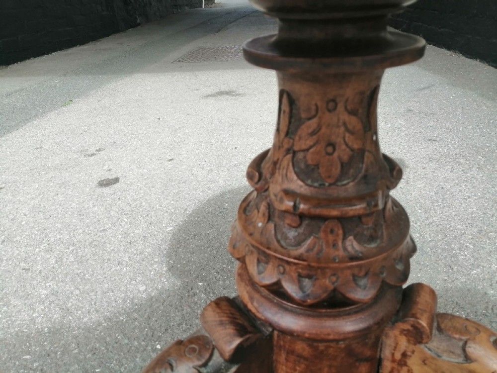 A 19th-century Victorian walnut rise and fall piano stool featuring a circular light blue patterned upholstered seat with fringed trim set on a carved tripod base. View V