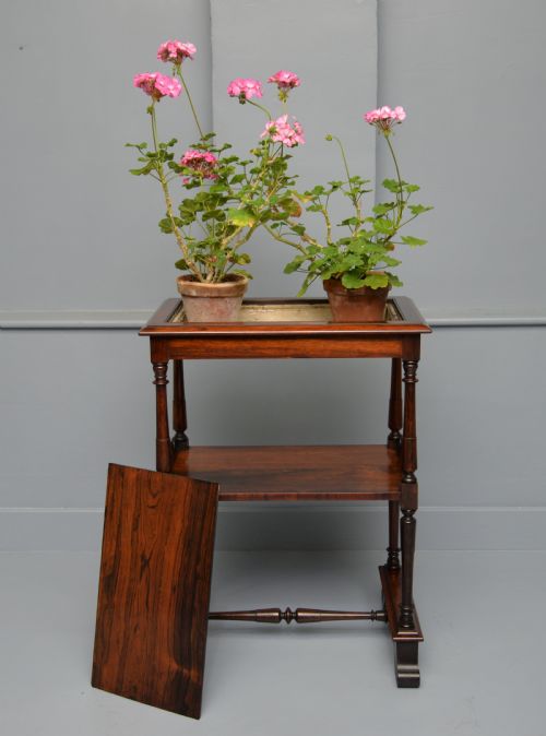 fig 1. A dark William IV rosewood plant stand with a recessed upper tray, turned support posts, a lower shelf with carved scrollwork, and scroll feet.