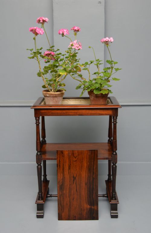 fig 2. A dark William IV rosewood plant stand with a recessed upper tray, turned support posts, a lower shelf with carved scrollwork, and scroll feet.