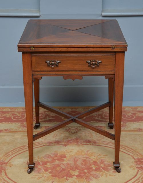 fig 4. An antique mahogany envelope card table featuring four triangular top flaps, a single drawer with brass drop handles, and tapered legs joined by an X-shaped stretcher.