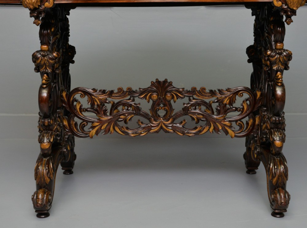 A 19th-century dark carved mahogany centre table featuring a shaped top, parcel-gilt mask corner details, and intricate openwork scroll legs. View III