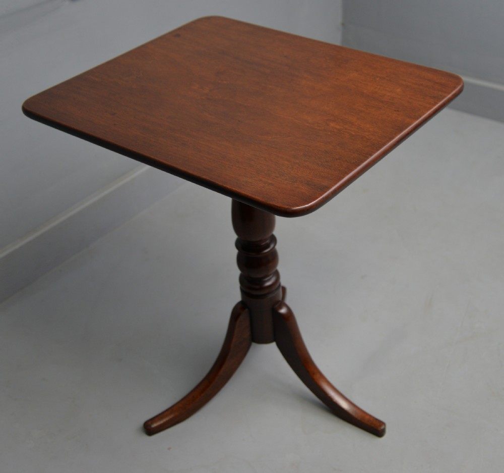 A Victorian solid mahogany wine table with a rectangular rounded top, a central turned pedestal, and a tripod base.