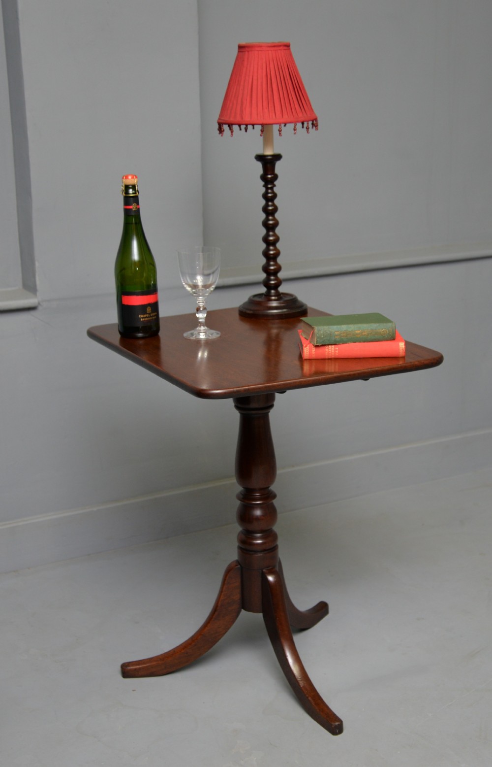 A Victorian solid mahogany wine table with a rectangular rounded top, a central turned pedestal, and a tripod base. View II