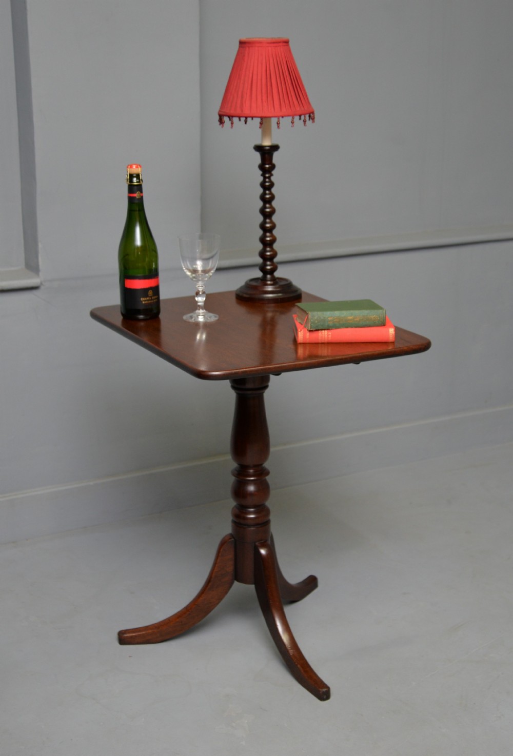 A Victorian solid mahogany wine table with a rectangular rounded top, a central turned pedestal, and a tripod base. View V
