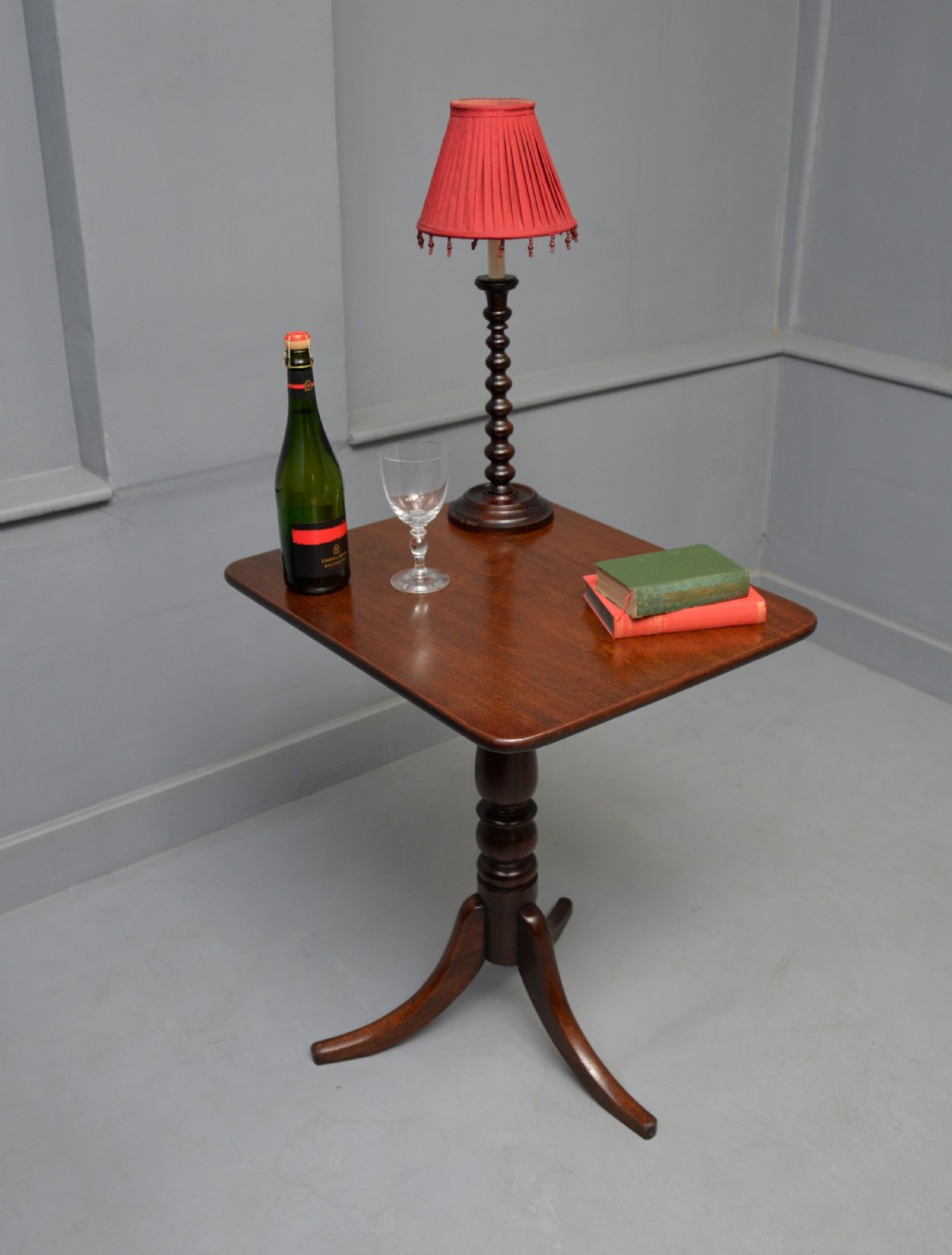 A Victorian solid mahogany wine table with a rectangular rounded top, a central turned pedestal, and a tripod base. View VII