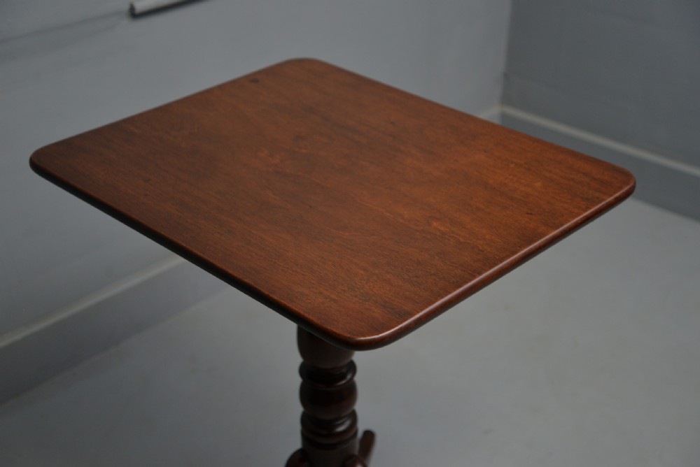 A Victorian solid mahogany wine table with a rectangular rounded top, a central turned pedestal, and a tripod base. View X
