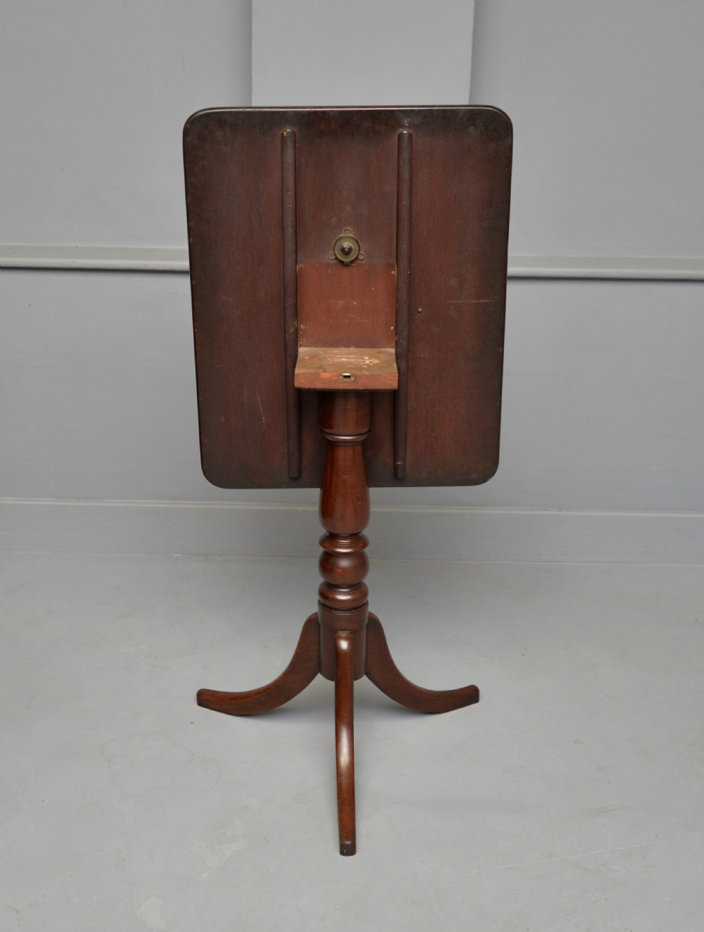 A Victorian solid mahogany wine table with a rectangular rounded top, a central turned pedestal, and a tripod base. View XII