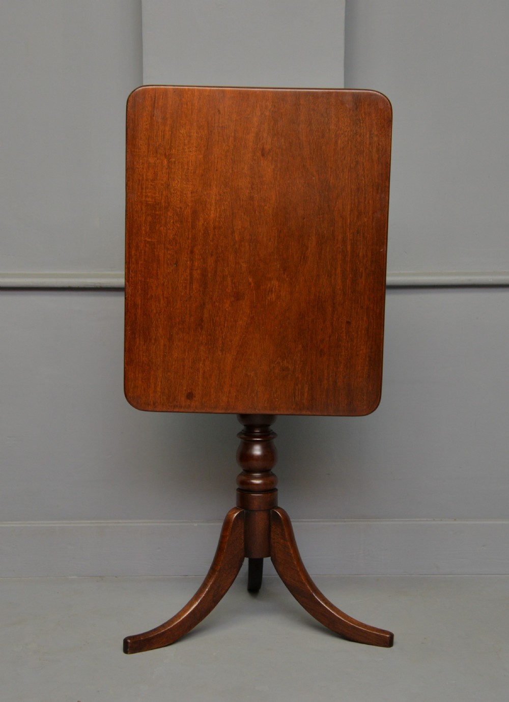 A Victorian solid mahogany wine table with a rectangular rounded top, a central turned pedestal, and a tripod base. View XV