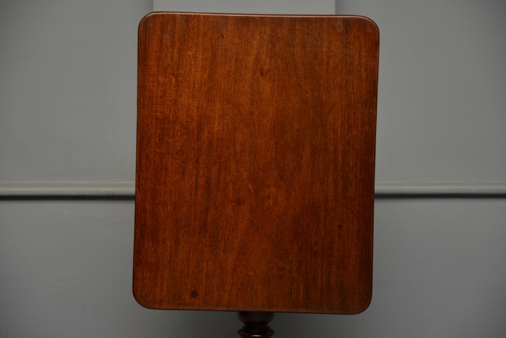 A Victorian solid mahogany wine table with a rectangular rounded top, a central turned pedestal, and a tripod base. View XVII