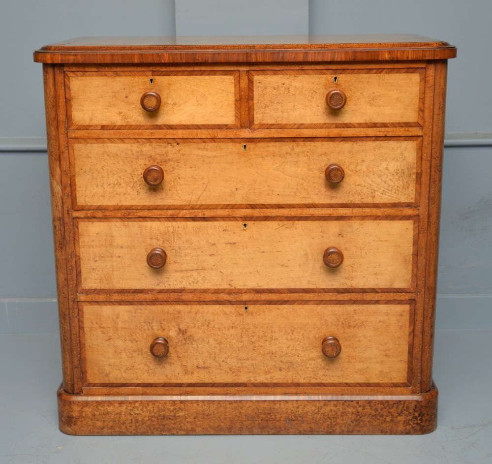 A Victorian satinwood chest of drawers featuring two small upper drawers above three full-width drawers with turned rosette knobs and a plinth base. View II