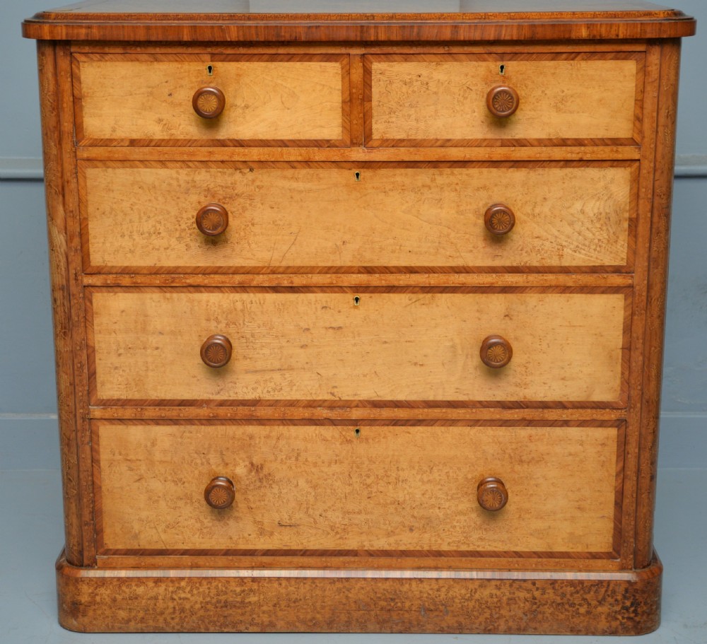 A Victorian satinwood chest of drawers featuring two small upper drawers above three full-width drawers with turned rosette knobs and a plinth base. View III