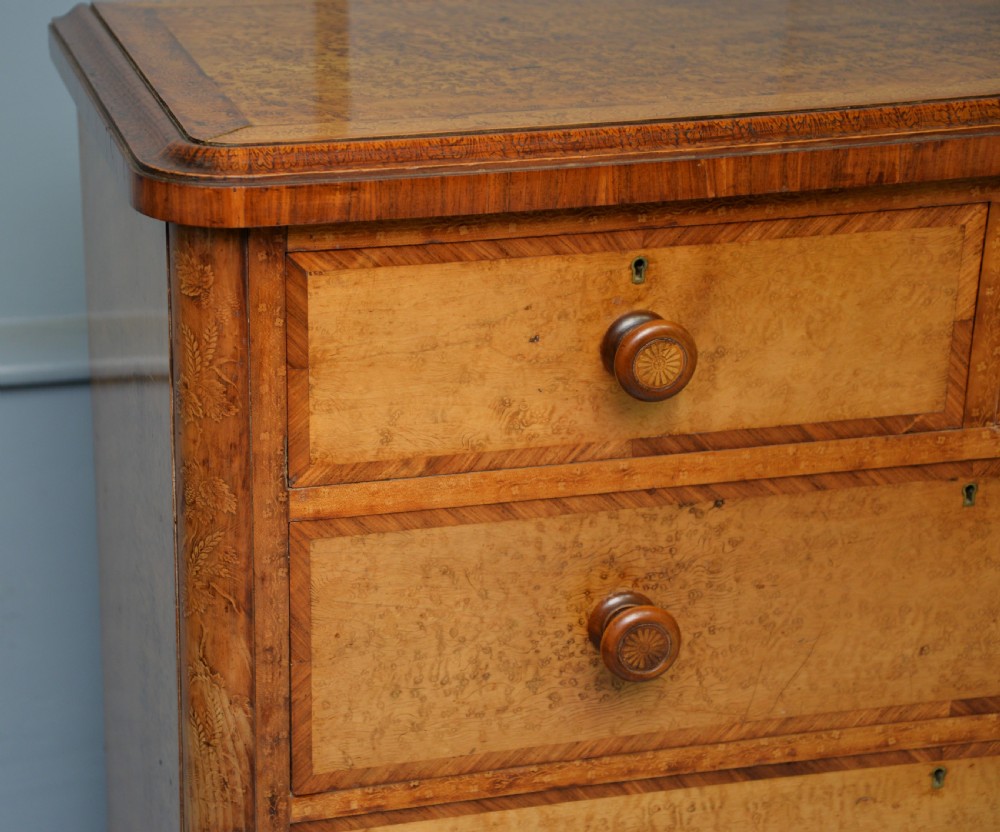 A Victorian satinwood chest of drawers featuring two small upper drawers above three full-width drawers with turned rosette knobs and a plinth base. View VII