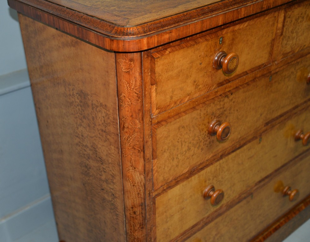 A Victorian satinwood chest of drawers featuring two small upper drawers above three full-width drawers with turned rosette knobs and a plinth base. View IX