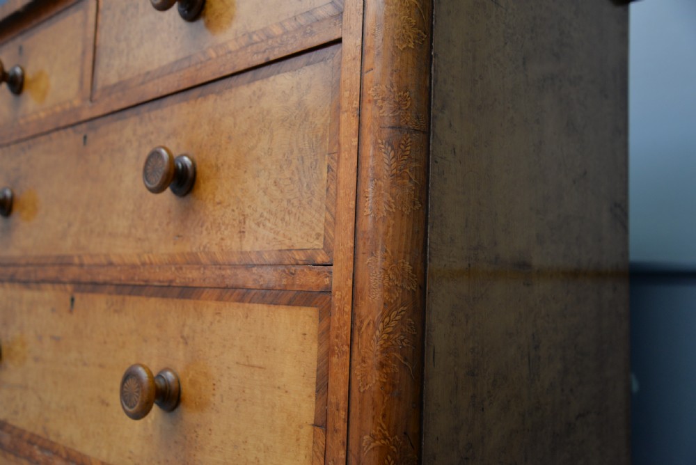 A Victorian satinwood chest of drawers featuring two small upper drawers above three full-width drawers with turned rosette knobs and a plinth base. View XIII