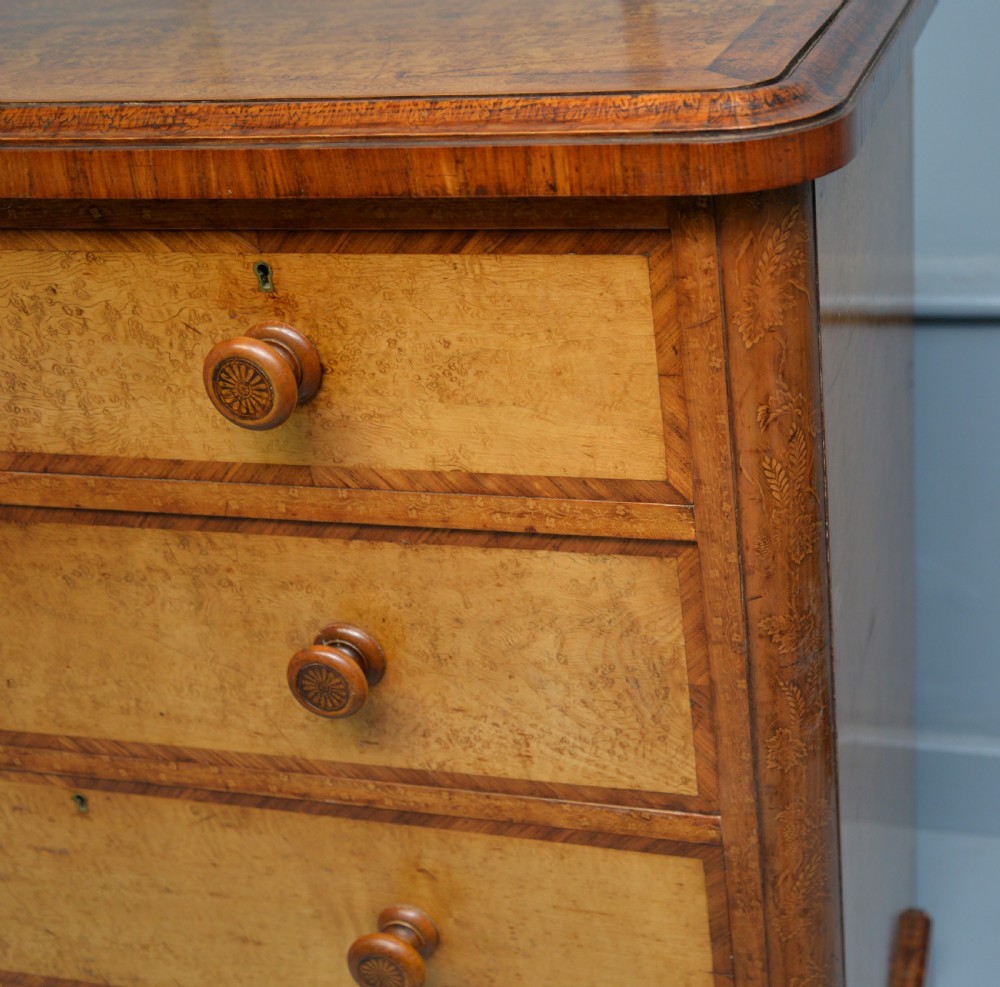 A Victorian satinwood chest of drawers featuring two small upper drawers above three full-width drawers with turned rosette knobs and a plinth base. View XIV