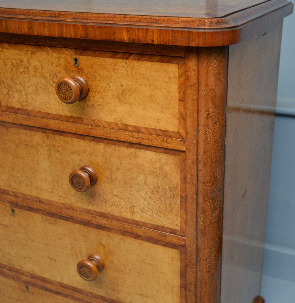 A Victorian satinwood chest of drawers featuring two small upper drawers above three full-width drawers with turned rosette knobs and a plinth base. View XVI