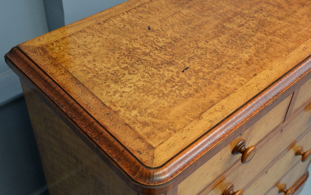 A Victorian satinwood chest of drawers featuring two small upper drawers above three full-width drawers with turned rosette knobs and a plinth base. View XVIII