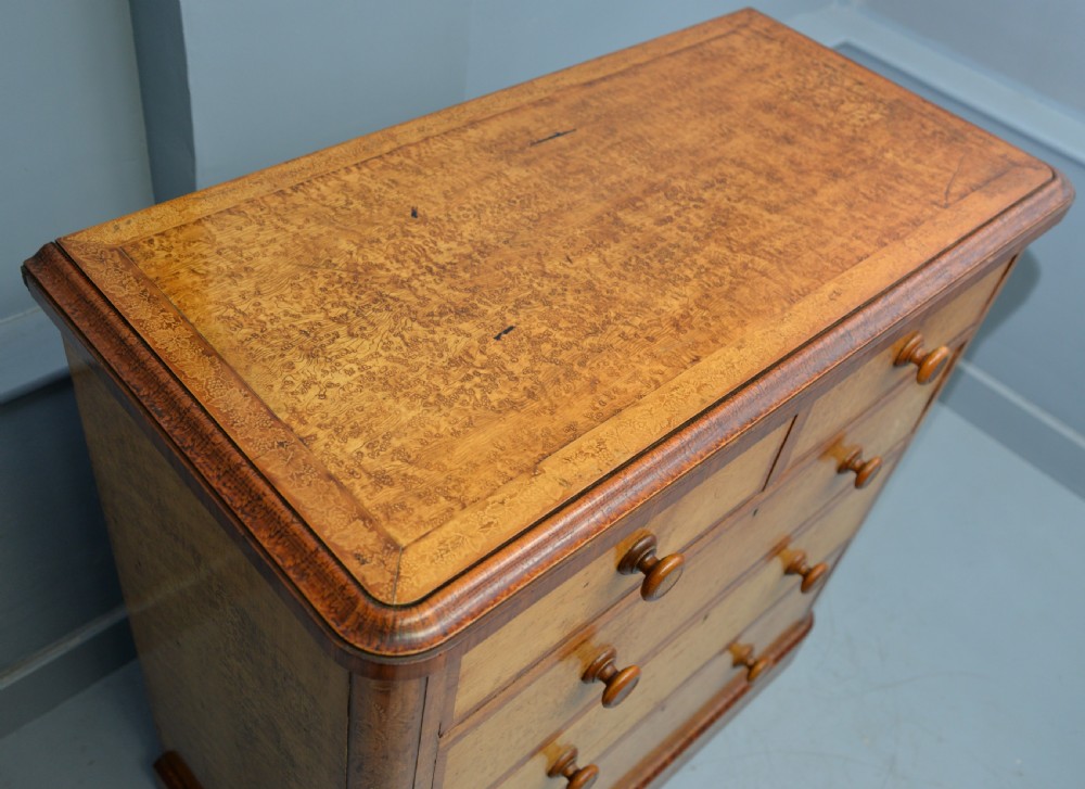 A Victorian satinwood chest of drawers featuring two small upper drawers above three full-width drawers with turned rosette knobs and a plinth base. View XIX