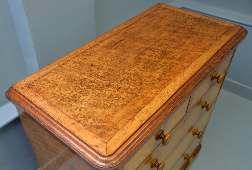 A Victorian satinwood chest of drawers featuring two small upper drawers above three full-width drawers with turned rosette knobs and a plinth base. View XXI