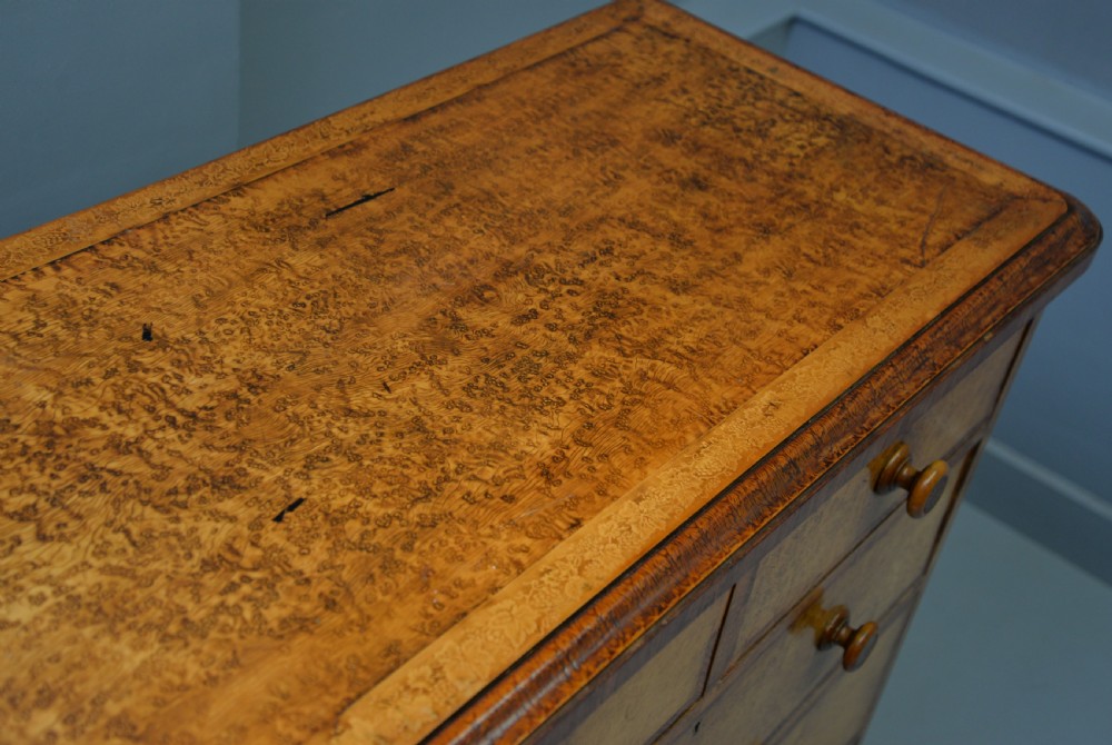 A Victorian satinwood chest of drawers featuring two small upper drawers above three full-width drawers with turned rosette knobs and a plinth base. View XXIII