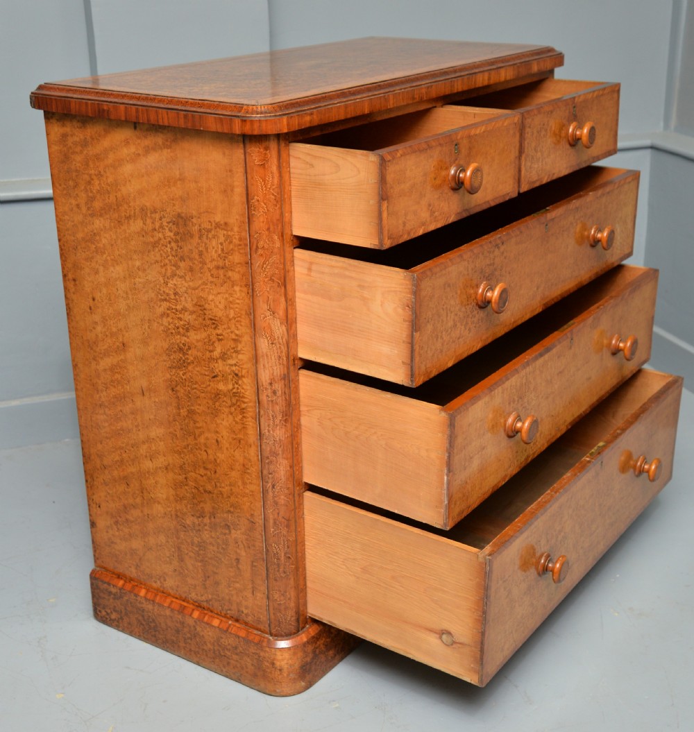 A Victorian satinwood chest of drawers featuring two small upper drawers above three full-width drawers with turned rosette knobs and a plinth base. View XXV