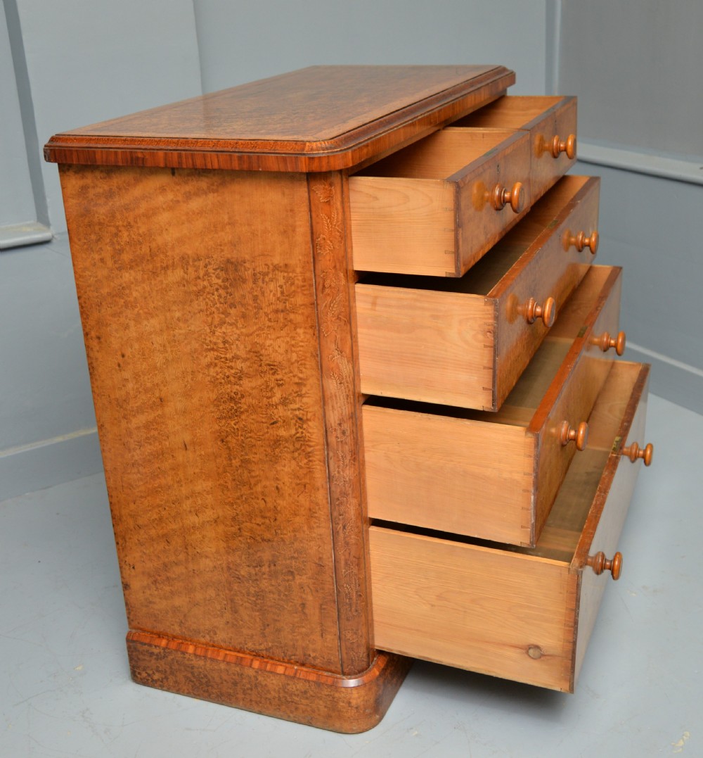 A Victorian satinwood chest of drawers featuring two small upper drawers above three full-width drawers with turned rosette knobs and a plinth base. View XXVI