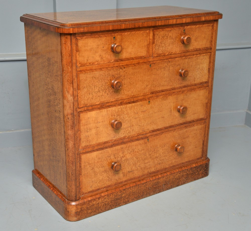 A Victorian satinwood chest of drawers featuring two small upper drawers above three full-width drawers with turned rosette knobs and a plinth base. View XXXI
