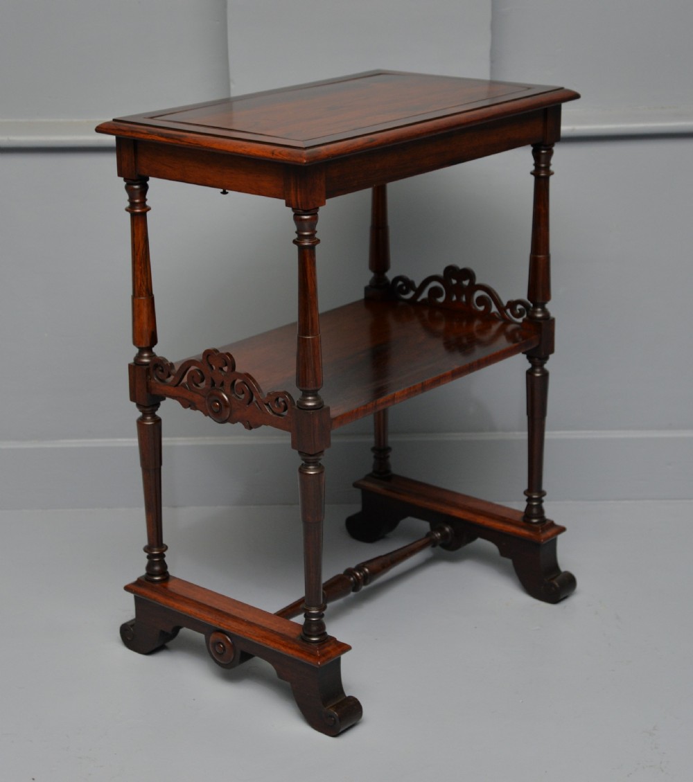 A dark William IV rosewood plant stand with a recessed upper tray, turned support posts, a lower shelf with carved scrollwork, and scroll feet. View XI
