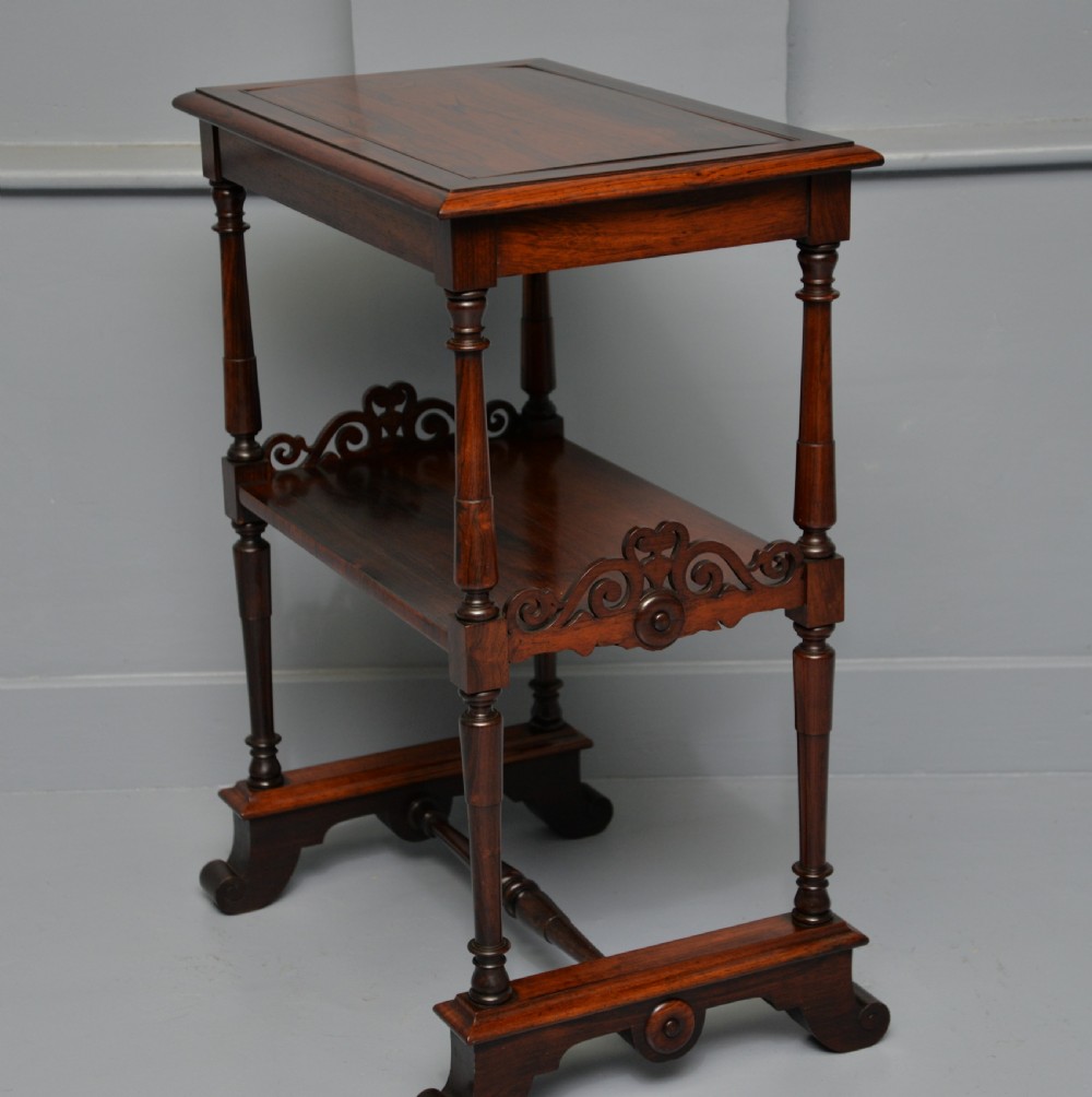 A dark William IV rosewood plant stand with a recessed upper tray, turned support posts, a lower shelf with carved scrollwork, and scroll feet. View XV