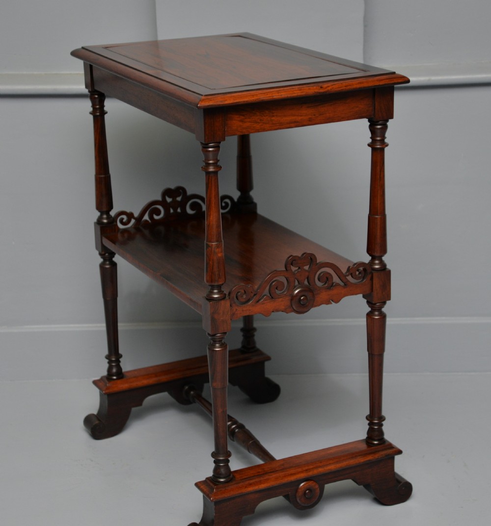 A dark William IV rosewood plant stand with a recessed upper tray, turned support posts, a lower shelf with carved scrollwork, and scroll feet. View XVI