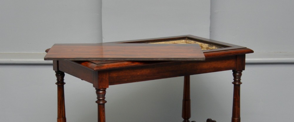A dark William IV rosewood plant stand with a recessed upper tray, turned support posts, a lower shelf with carved scrollwork, and scroll feet. View XX