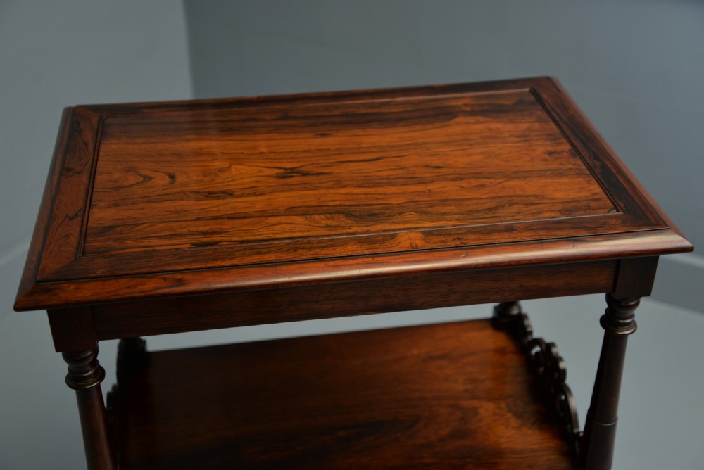A dark William IV rosewood plant stand with a recessed upper tray, turned support posts, a lower shelf with carved scrollwork, and scroll feet. View XXI