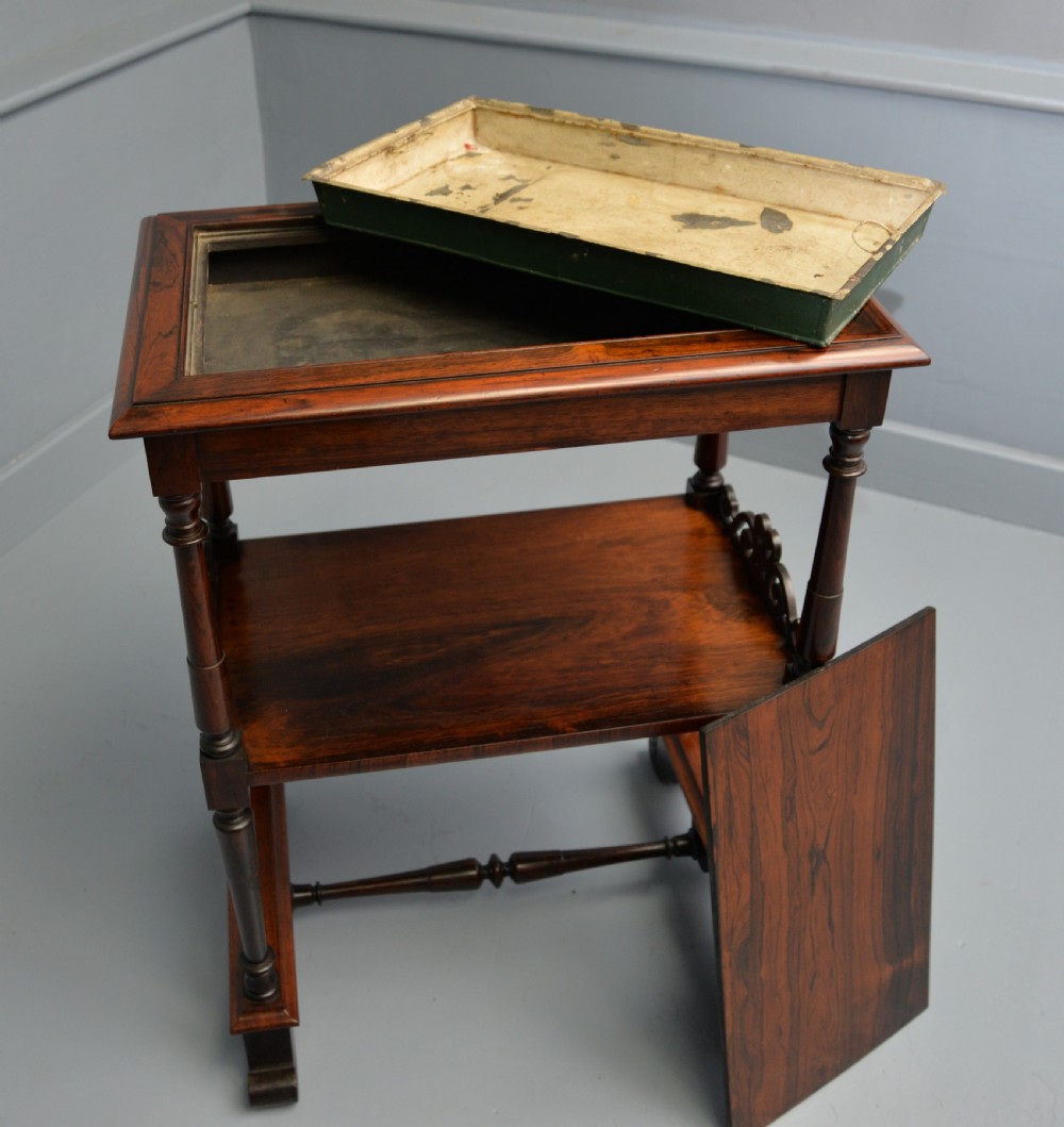 A dark William IV rosewood plant stand with a recessed upper tray, turned support posts, a lower shelf with carved scrollwork, and scroll feet. View XXIV