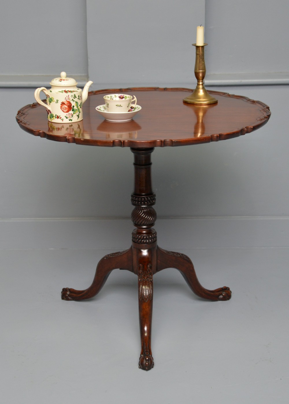 An 18th-century George III mahogany tripod table featuring a circular pie-crust rim, carved turned column, and cabriole legs ending in claw and ball feet. View III