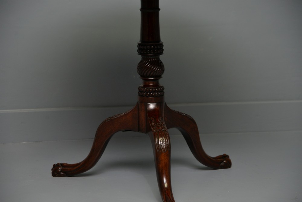 An 18th-century George III mahogany tripod table featuring a circular pie-crust rim, carved turned column, and cabriole legs ending in claw and ball feet. View XI