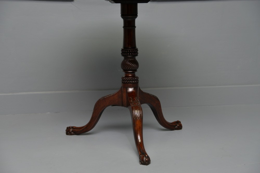 An 18th-century George III mahogany tripod table featuring a circular pie-crust rim, carved turned column, and cabriole legs ending in claw and ball feet. View XII