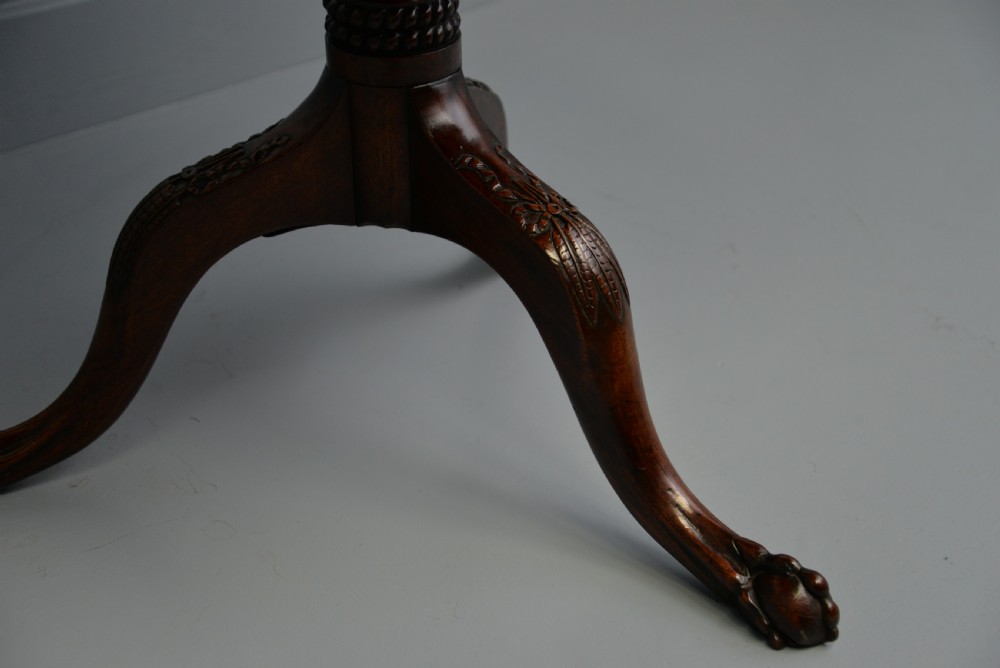 An 18th-century George III mahogany tripod table featuring a circular pie-crust rim, carved turned column, and cabriole legs ending in claw and ball feet. View XIV