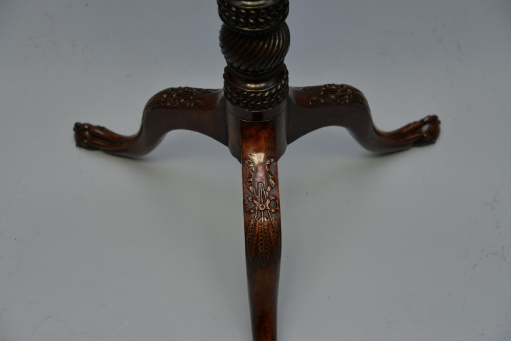 An 18th-century George III mahogany tripod table featuring a circular pie-crust rim, carved turned column, and cabriole legs ending in claw and ball feet. View XIX