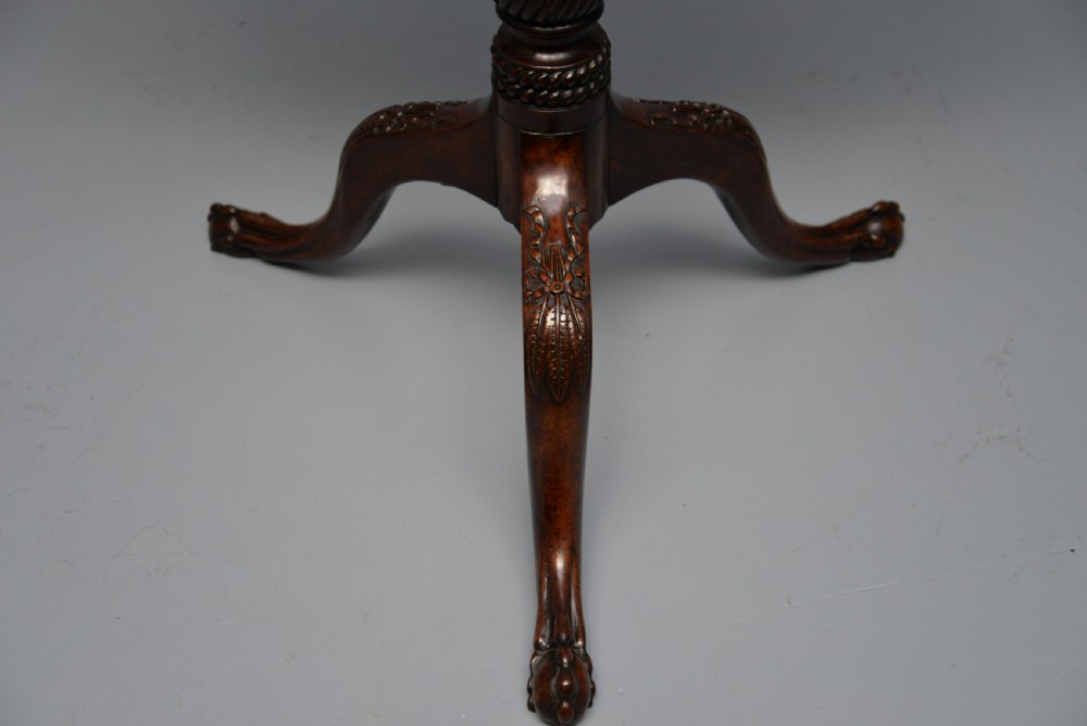 An 18th-century George III mahogany tripod table featuring a circular pie-crust rim, carved turned column, and cabriole legs ending in claw and ball feet. View XX