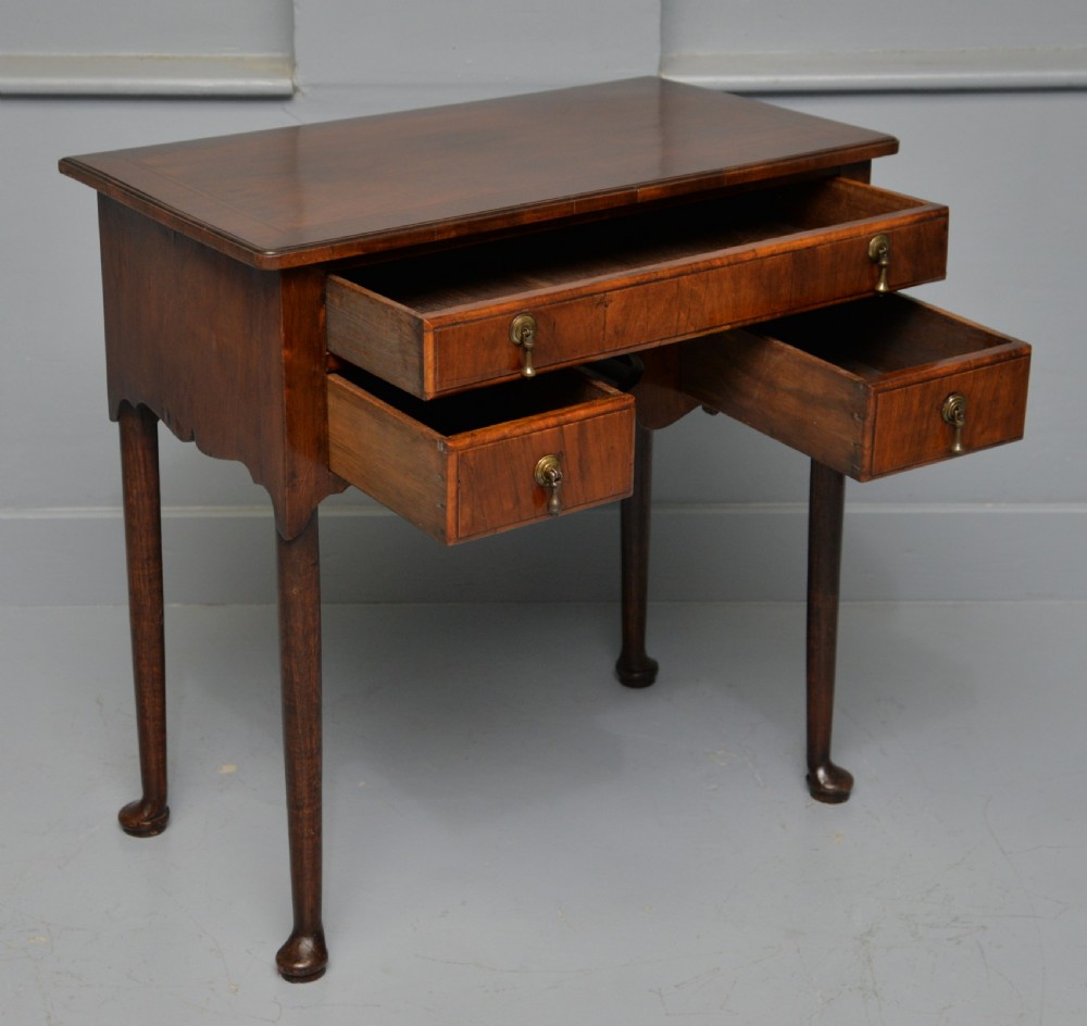 A George II revival walnut lowboy side table featuring three drawers with brass drop handles, a shaped kneehole apron, and slender cabriole legs with pad feet. View VIII