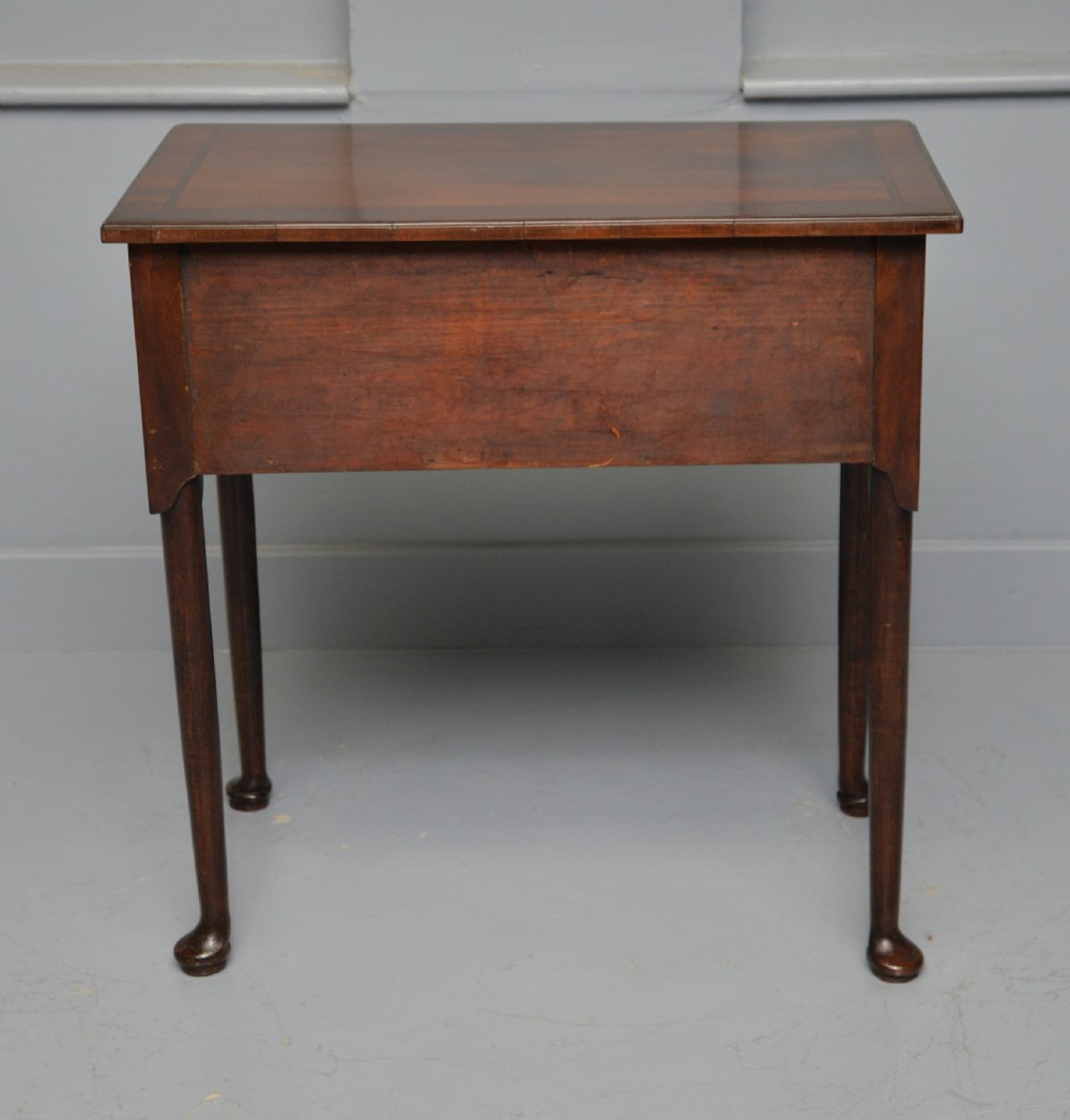 A George II revival walnut lowboy side table featuring three drawers with brass drop handles, a shaped kneehole apron, and slender cabriole legs with pad feet. View X
