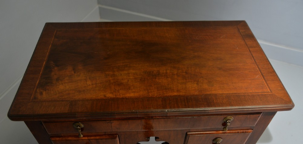 A George II revival walnut lowboy side table featuring three drawers with brass drop handles, a shaped kneehole apron, and slender cabriole legs with pad feet. View XIII