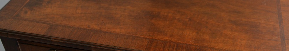A George II revival walnut lowboy side table featuring three drawers with brass drop handles, a shaped kneehole apron, and slender cabriole legs with pad feet. View XIV
