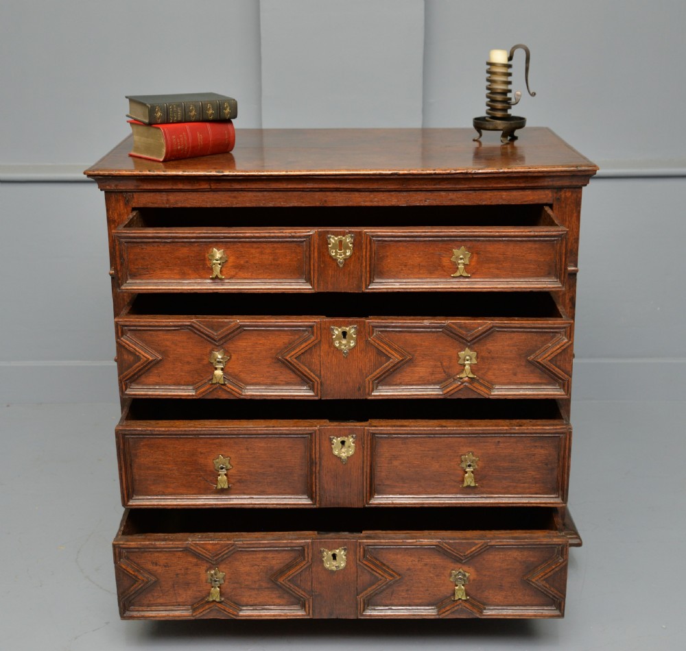 A 17th-century oak chest of drawers featuring geometric panel mouldings across four drawer fronts and brass drop handles. View III