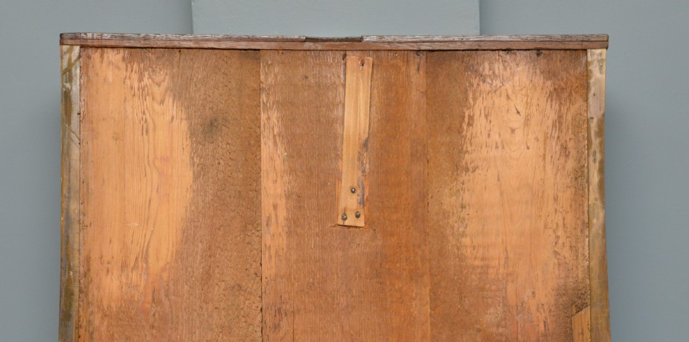 A 17th-century oak chest of drawers featuring geometric panel mouldings across four drawer fronts and brass drop handles. View XVII
