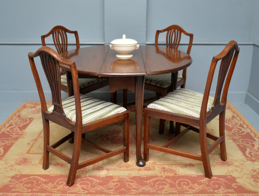 A George II mahogany drop-leaf dining table supported by slender tapered legs ending in pad feet. View II