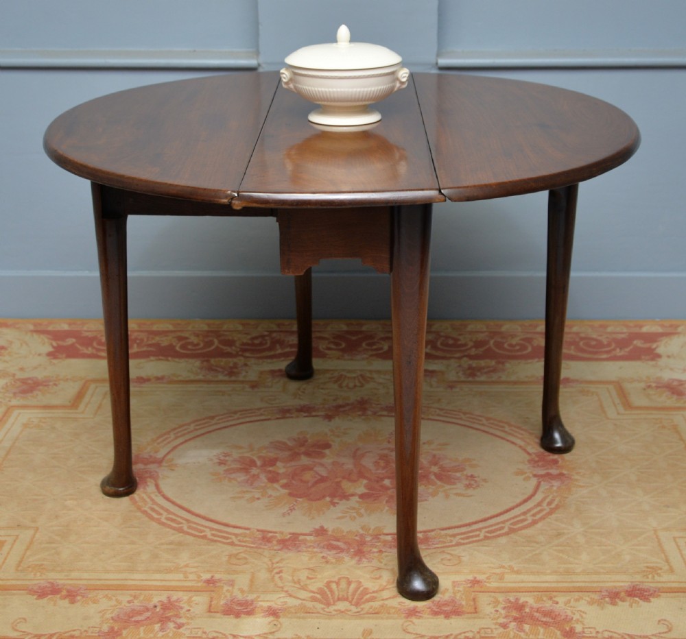 A George II mahogany drop-leaf dining table supported by slender tapered legs ending in pad feet. View V