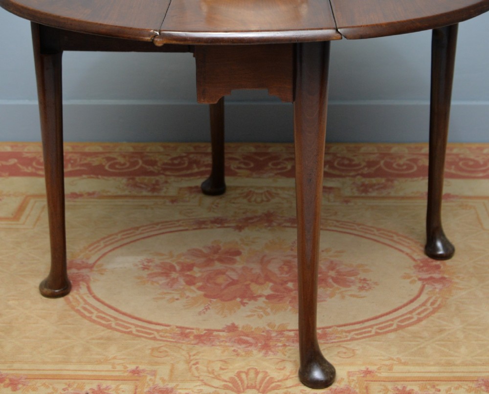 A George II mahogany drop-leaf dining table supported by slender tapered legs ending in pad feet. View VI
