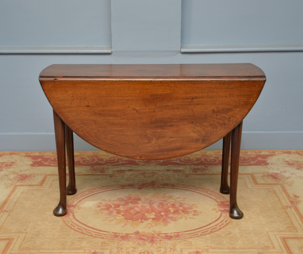 A George II mahogany drop-leaf dining table supported by slender tapered legs ending in pad feet. View IX